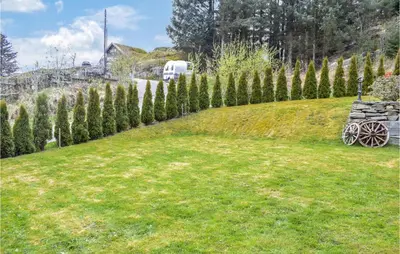 a garden with a bench and a fence with trees at Amazing Apartment In Fjell in Lokøy