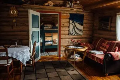 a living room with a couch and a table in a cabin at Gammelstuggu in Bjorli