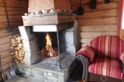 a fireplace in a room with a couch in front of it at Gammelstuggu in Bjorli