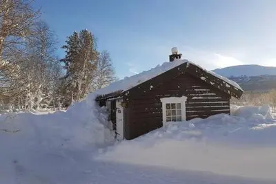 a small log cabin with snow around it at Gammelstuggu in Bjorli