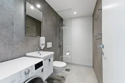 a bathroom with a sink and a toilet and a mirror at Aalesund City Apartment in Ålesund