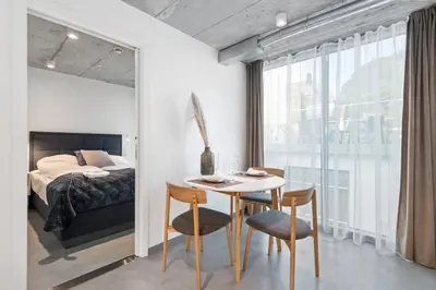 a bedroom with a table and chairs and a bed at Aalesund City Apartment in Ålesund