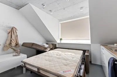a small bedroom with a bed and a window at Aalesund City Apartment in Ålesund