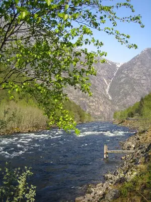 a view of a river with mountains in the background at Kvamsdal Pensjonat 3 in Eidfjord