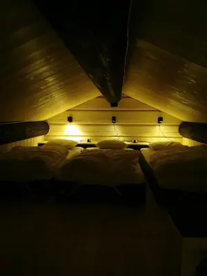 a dark room with three beds in a row at STORHAUGEN GARD in Lom