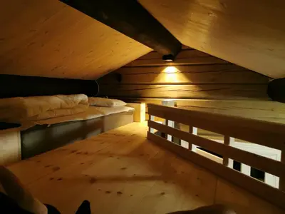an attic room with two beds and a wooden floor at STORHAUGEN GARD in Lom