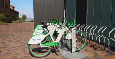 a row of green and white bikes parked next to a fence at Cityfjord apartment in Bergen centrum in Bergen