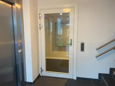 a glass door in a bathroom with a window at Cityfjord apartment in Bergen centrum in Bergen
