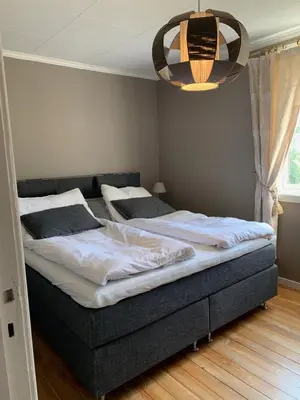 two beds in a bedroom with a chandelier at Moldegaard Farmhouse - Apartment A in Moldegard