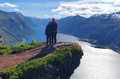 two people standing on top of a mountain overlooking a river at Irenegarden - Fjord view holiday home in Lauvstad