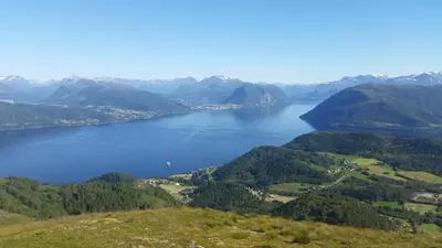a view of a lake in the middle of mountains at Irenegarden - Fjord view holiday home in Lauvstad