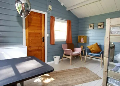 a room with blue walls and a table and chairs at Ljoshaugen Camping in Dombås