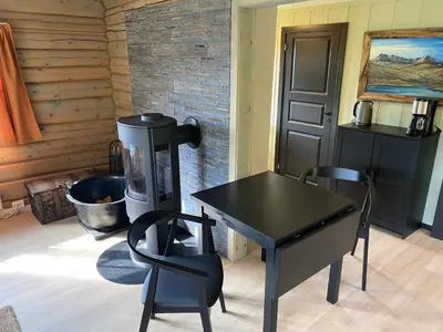 a room with a table and two chairs and a stove at Ljoshaugen Camping in Dombås