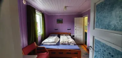 a small bedroom with a bed in a purple room at Midtgard in Tyinkrysset