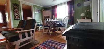 a living room with a piano and a table and chairs at Midtgard in Tyinkrysset