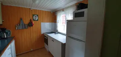 a kitchen with a white refrigerator and a window at Midtgard in Tyinkrysset