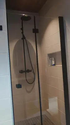 a shower in a bathroom with a cross on the wall at Hytte i Stryn med elbil lader in Stryn