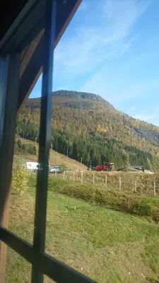 a view from a window of a field with a mountain at Hytte i Stryn med elbil lader in Stryn