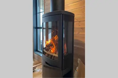 a fireplace with a fire in it in a room at Hytte i Stryn med elbil lader in Stryn