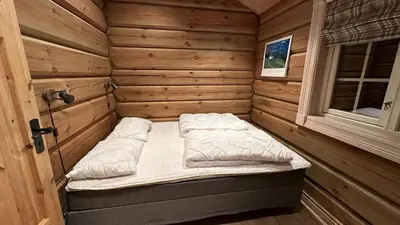 a small room with a bed in a wooden cabin at Liaplassen Mountain View in Beitostøl