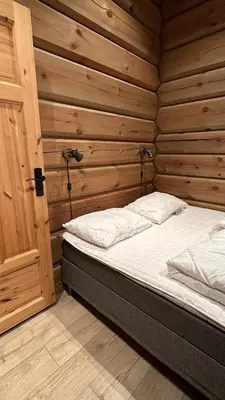 a bedroom with a bed in a wooden wall at Liaplassen Mountain View in Beitostøl