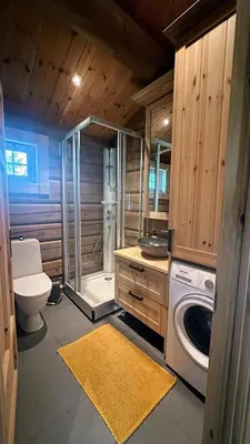 a bathroom with a shower and a washing machine at Liaplassen Mountain View in Beitostøl