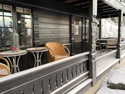 a porch of a cabin with tables and chairs at Ski and Bike-In and Out in Hafjell