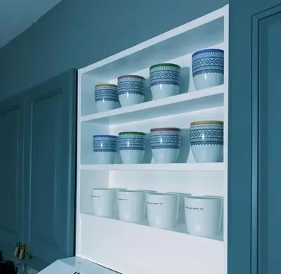a shelf with blue and white cups on it at Fjellstova Storehorn Apartments in Torset
