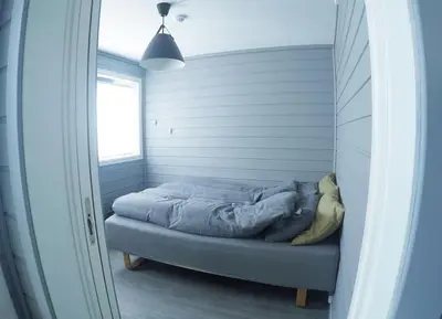 a small bed in a room with a window at Fjellstova Storehorn Apartments in Torset