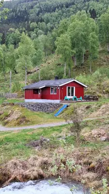 a red house on the side of a hill at Nordfjordcabins RED in Utvik