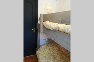 a bunk bed in a room with a blue door at Nordfjordcabins RED in Utvik