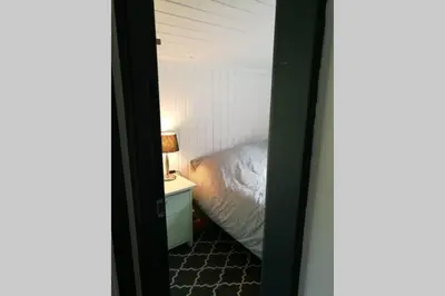 a bedroom with a bed and a table with a lamp at Nordfjordcabins RED in Utvik