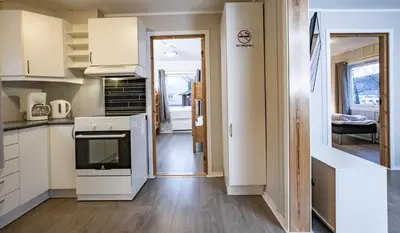 a kitchen with white cabinets and a tv in it at Lillehammer Camping in Lillehammer