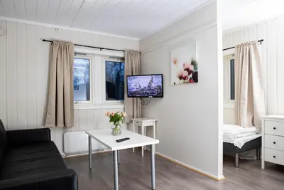 a living room with a couch and a tv on a wall at Lillehammer Camping in Lillehammer