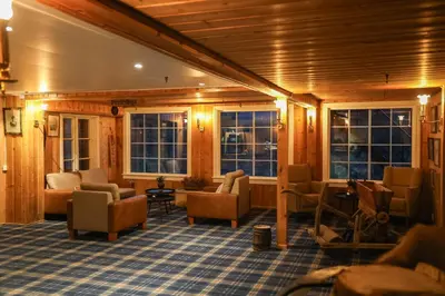 a living room with chairs and windows at Pollfoss Boutique Hotel & Spa in Skjåk