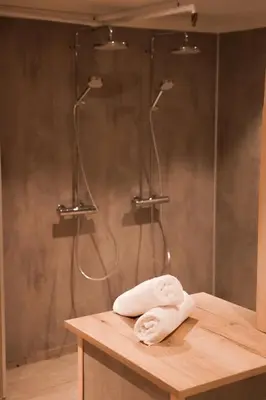 a bathroom with a shower with a towel on a counter at Pollfoss Boutique Hotel & Spa in Skjåk