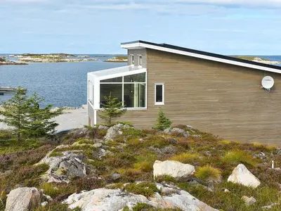 a house on top of a hill near the water at 6 person holiday home in Dyrvik in Dyrvik