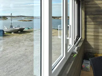 a window on a house with a view of the water at 6 person holiday home in Dyrvik in Dyrvik