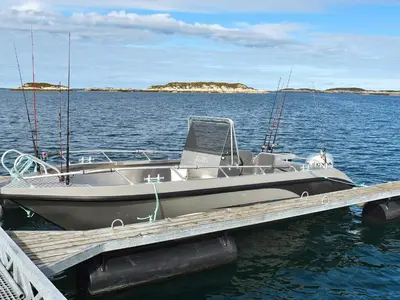 a boat is docked at a dock in the water at 6 person holiday home in Dyrvik in Dyrvik