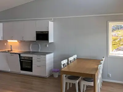 a kitchen and dining room with a table and chairs at 6 person holiday home in Dyrvik in Dyrvik