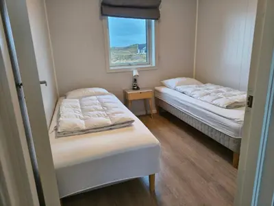 two beds in a small room with a window at 6 person holiday home in Dyrvik in Dyrvik