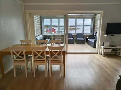 a dining room with a table and chairs and a living room at 6 person holiday home in Dyrvik in Dyrvik
