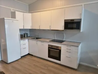 a kitchen with white cabinets and a refrigerator at 6 person holiday home in Dyrvik in Dyrvik