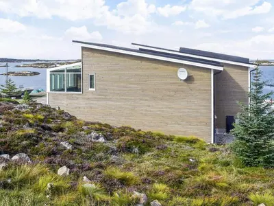 a house on top of a hill with water at 6 person holiday home in Dyrvik in Dyrvik