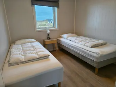 two beds in a room with a window at 6 person holiday home in Dyrvik in Dyrvik