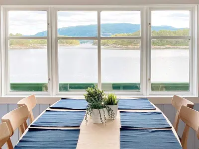 a dining room with a table with a view of the water at 6 person holiday home in LINDÅS in Lindås