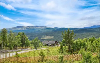 a view of a farm with mountains in the background at Moltebæret in Skåbu