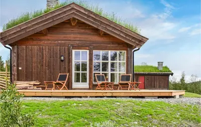 a cabin with chairs on a deck in the grass at Moltebæret in Skåbu