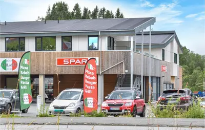 a parking lot with cars parked in front of a store at Beautiful Apartment In Årland With Wifi in Hålland
