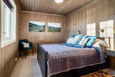 a bedroom with a bed in a wooden room at Villa Budor - 60 min fra OSL - Jaccuzzi - 4 soverom in Nordset